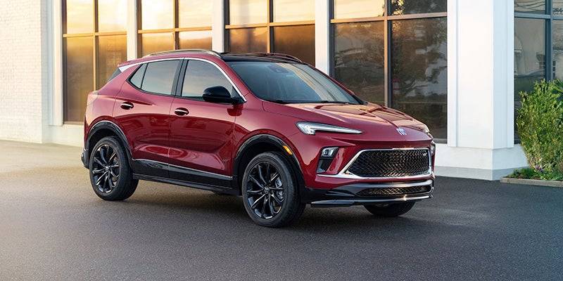 Buick Envista SUV parked on an asphalt lot in front of a modern building with large reflective windows.