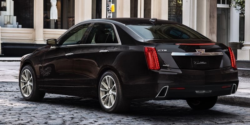 Silver Cadillac sedan rear view in an open parking area