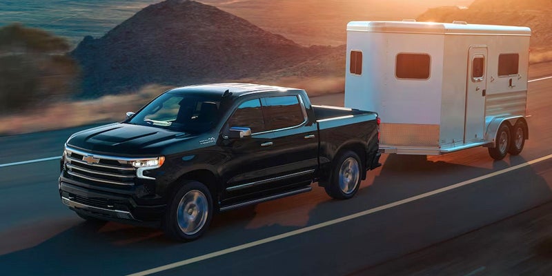 a black Chevy Silverado truck tows a trailer