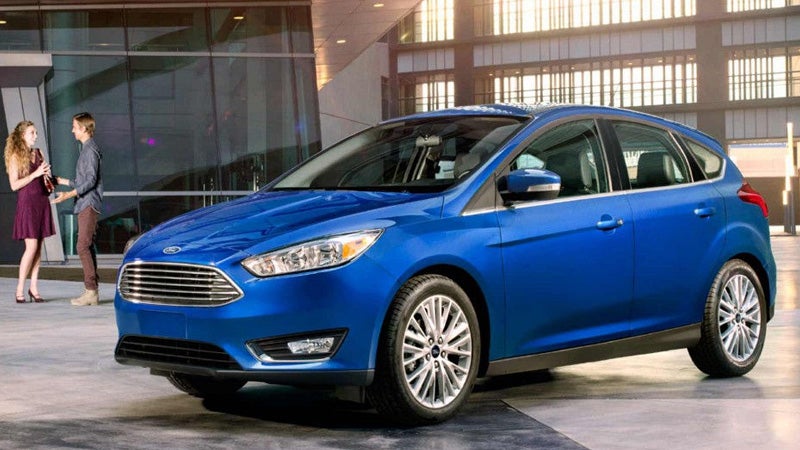 Blue Ford Focus parked outside a modern building with clean exterior design
