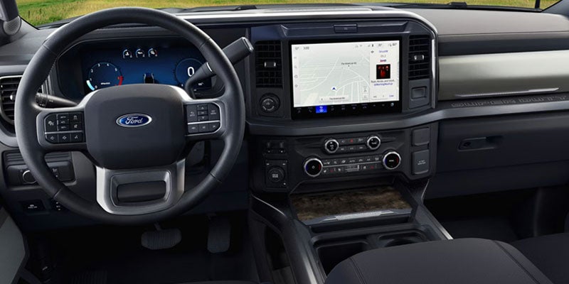 Interior shot of a Ford truck dashboard, featuring a large infotainment screen and digital gauge cluster.