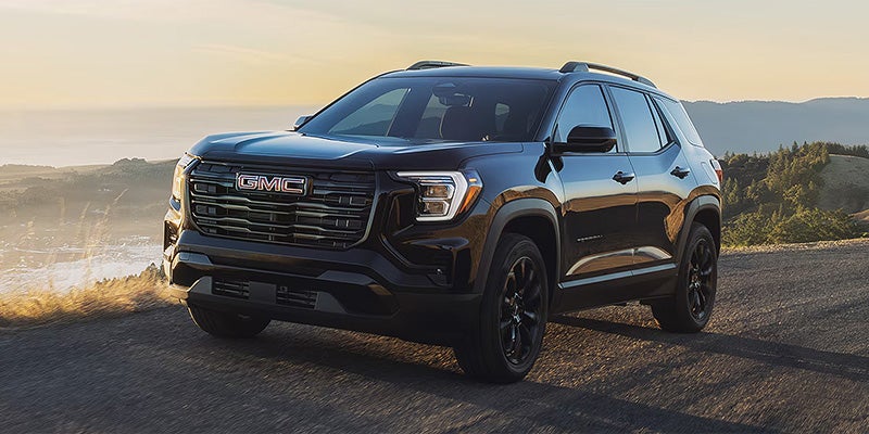 GMC Terrain SUV driving on a scenic road at sunset