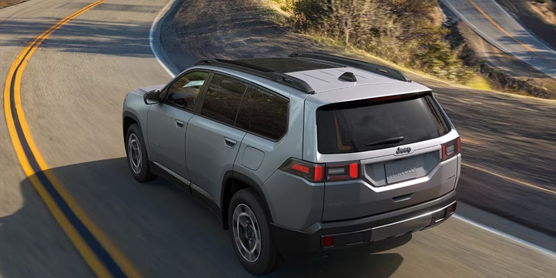 SUV driving on highway with rear view on open road