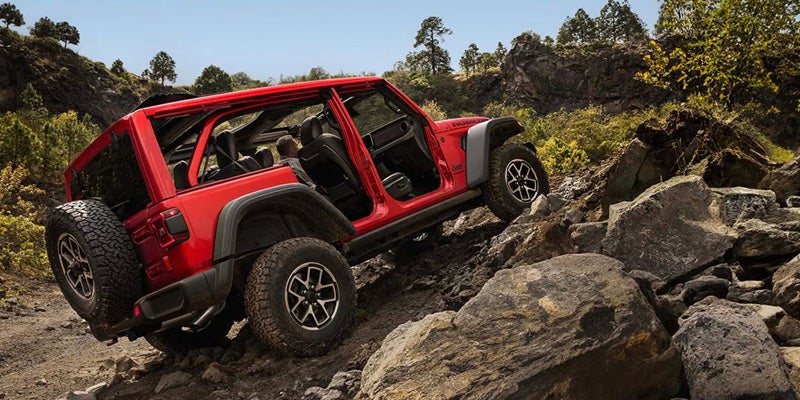 Red off-road SUV climbing rocky terrain