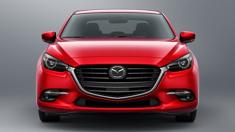 Front view of a shiny, bright red Mazda 3 sedan with black grille