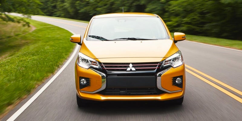 Front view of an orange Mitsubishi car on a road