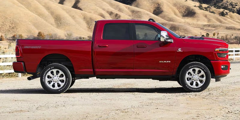 Ram 2500 Heavy Duty Limited pickup truck on a dirt road, with hills in the background.